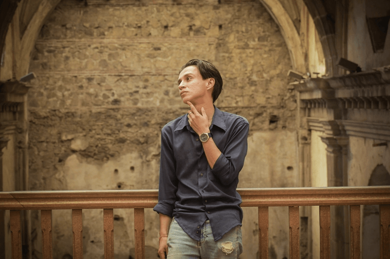 Example image of a person standing in front of historic stone arches